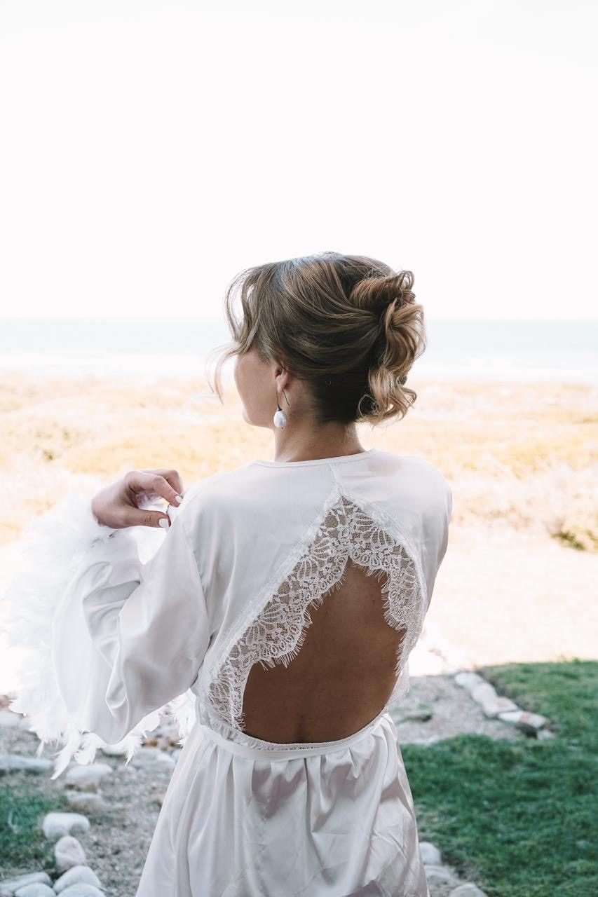 Bride at the beach with an open lace back updo