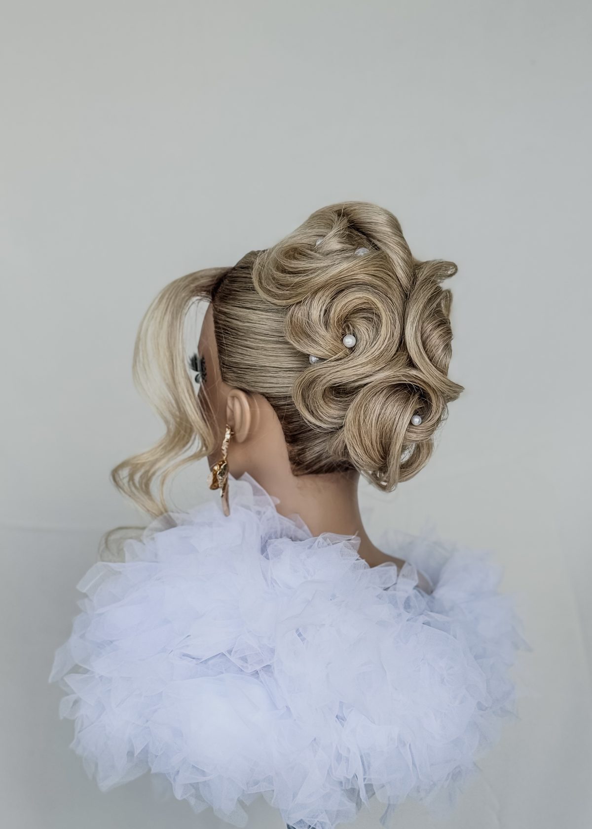 Sleek low bun bridal updo with pearl detail