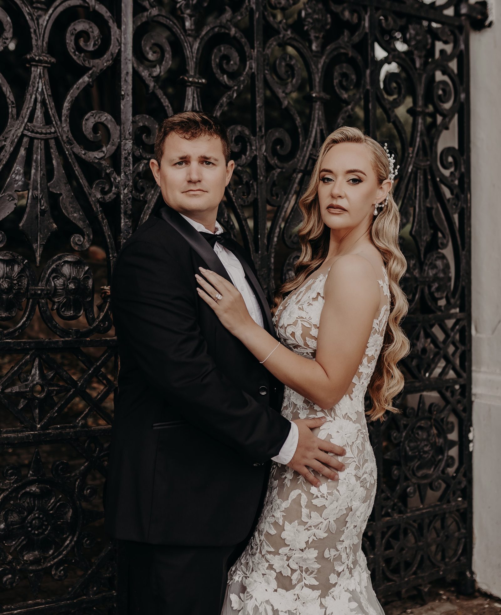 Bride and groom portrait against wrought iron gate