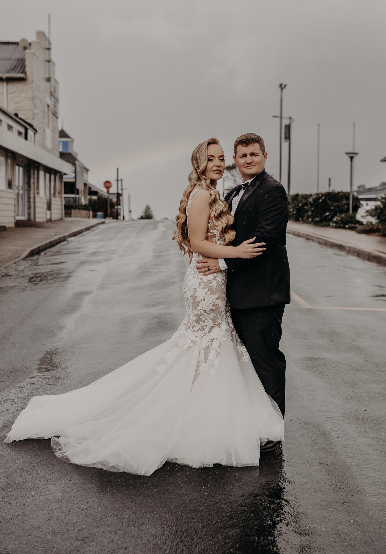 Bride and groom in rain with long curled hair